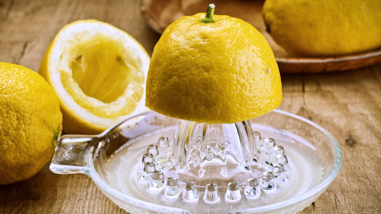 Cut,Lemons,And,Juicer,On,Wooden,Table