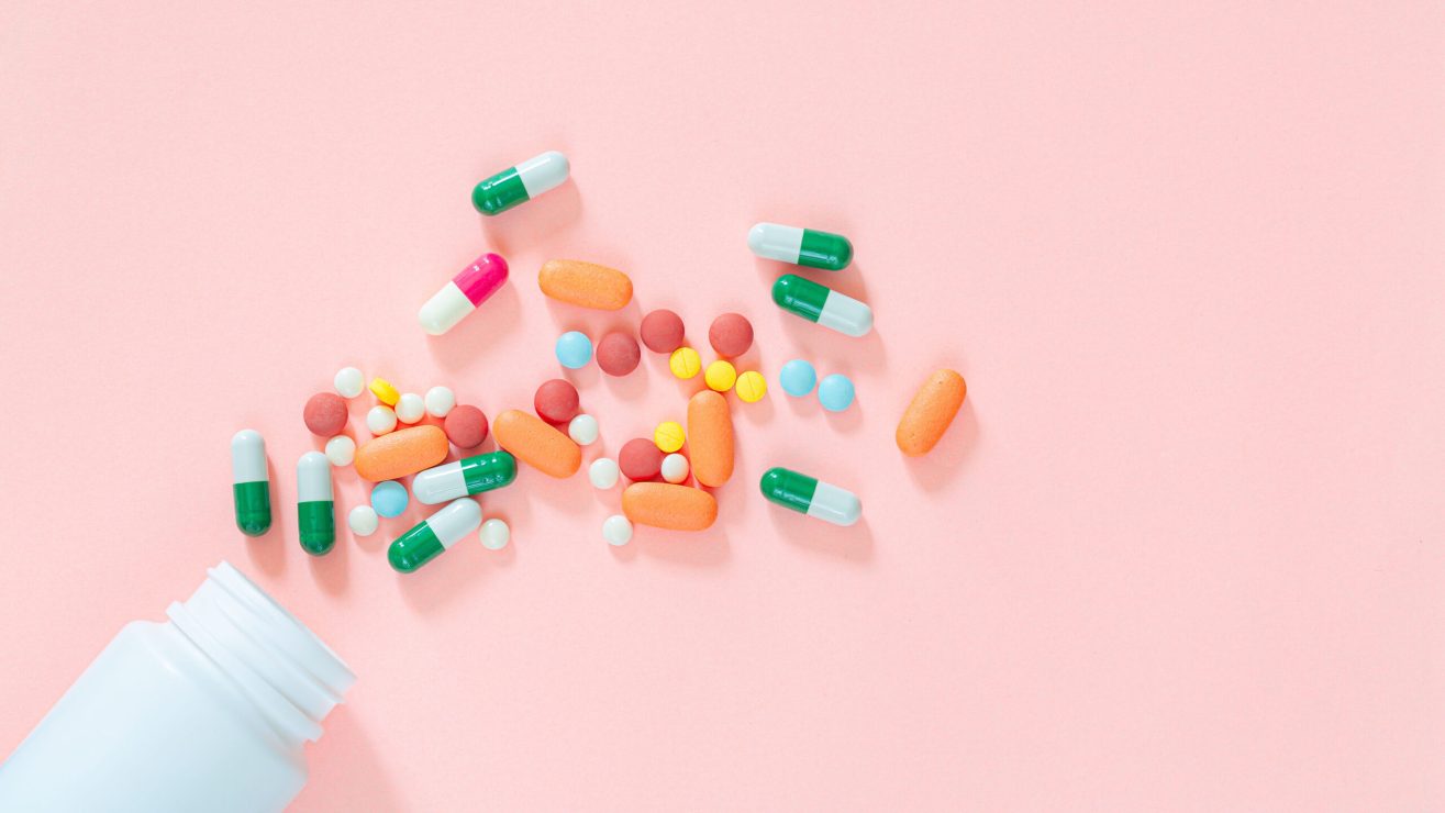 Pills,And,Pill,Bottles,On,Pink,Background,assorted,Pharmaceutical,Medicine,Pills,