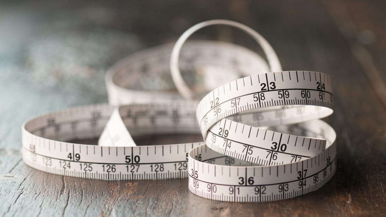 Close,Up,Tailor,Measuring,Tape,On,Wooden,Table,Background.,White